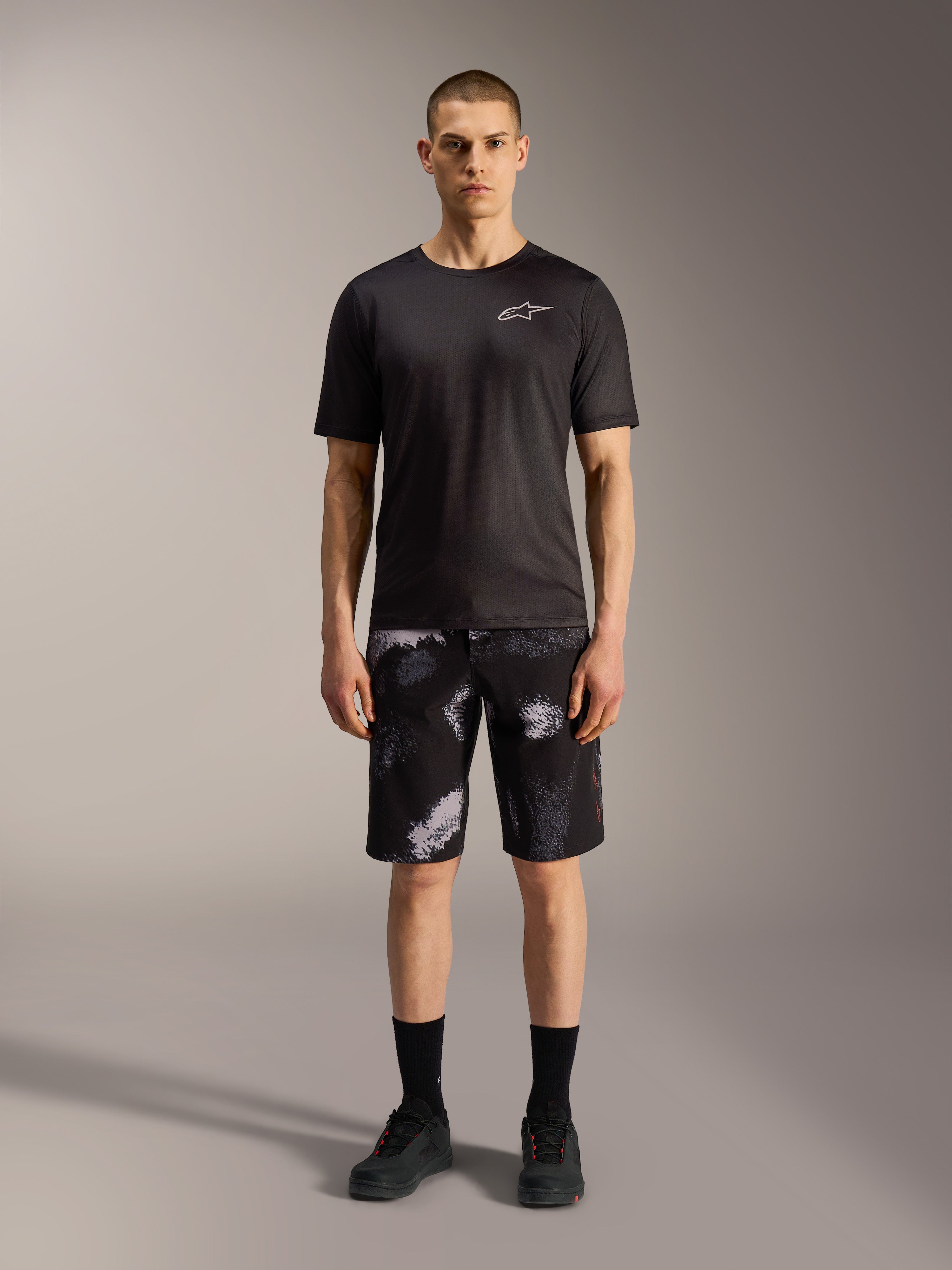 Alpinestars A-Dura Ride shorts in Black Camo, gecombineerd met een zwart performance shirt voor MTB-veelzijdigheid.