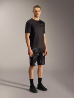 A-Dura Ride MTB-shorts in Black Camo met grijs camouflagepatroon, gecombineerd met een zwart shirt en schoenen.
