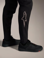 Zwarte A-Supra Elite MTB-broek met zilveren Astars-logo op het onderbeen voor high-performance mountainbiken.