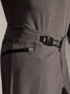Alpinestars A-Dura Elite Pants, MTB Pants, Dark Gray, close-up view showing the front ratchet closure system and zippered pocket, technical cycling gear for mountain biking