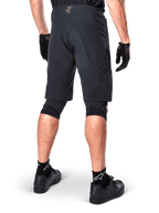 Alpinestars A-Aria Elite Shorts in het zwart, prestatiegerichte mountainbike short, achteraanzicht van een fietser met zwarte fietshandschoenen en zwarte schoenen, ontworpen voor optimale bewegingsvrijheid op off-road trails