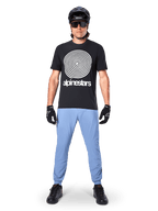 Alpinestars A-Dura Pants, Infinity Blue, MTB Pants worn with a black spiral graphic t-shirt, black gloves, and a black helmet, featuring a durable stretch fabric and elasticated cuffs, performance mountain bike gear