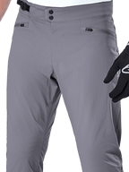 Alpinestars A-Dura Pants, MTB-broek, donkergrijs, close-up van de taille met dubbele drukknoopsluiting, verstelbare zijsluiting en zakken met ritssluiting, duurzame stretchstof voor mountainbiken