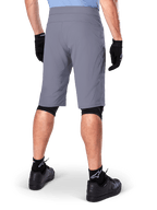Alpinestars A-Dura Shorts, Dark Gray Mountain Bike Shorts, rear view shown on a rider, worn with black gloves, black knee liners, and black Alpinestars logo socks, durable construction for off-road cycling