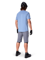 Alpinestars A-Dura Shorts, Dark Gray MTB Shorts, rear view, worn with a light blue short-sleeve jersey and black mountain bike helmet, black gloves and socks with black shoes, functional and durable gear for off-road cycling