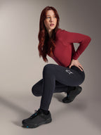 Alpinestars Stella A-Dura Thermal broek, MTB-broek voor dames, zwart, gedragen door een model in een gehurkte houding met een bordeauxrode top met lange mouwen en zwarte fietsschoenen, voorzien van een wit sterlogo op de dij, duurzame en warme constructie voor off-road ritten in koud weer