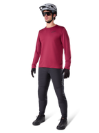 Alpinestars A-Dura Thermal Jersey in burgundy, geïsoleerd mountainbikeshirt met lange mouwen, gedragen met een donkergrijze mountainbikebroek, zwarte handschoenen en een grijze helm, studio-opname van volledige MTB-uitrusting voor koud weer.
