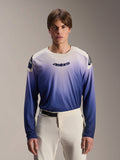 Alpinestars A-Aria Polartec Maker Elite jersey met lange mouwen, MTB-shirt, Baja Blue met een kleurverloop van wit naar blauw, gedragen door een model met een witte broek, donkerblauw logo op de borst en laserperforaties op de mouwen, technische mountainbikekleding