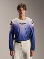 Alpinestars A-Aria Polartec Maker Elite jersey met lange mouwen, MTB-shirt, Baja Blue met een kleurverloop van wit naar blauw, gedragen door een model met een witte broek, donkerblauw logo op de borst en laserperforaties op de mouwen, technische mountainbikekleding
