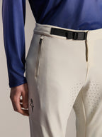 Alpinestars A-Aria Elite broek, mountainbikebroek, ecru, close-up van een zwarte magnetische gespsluiting in de taille, zak met rits en lasergesneden ventilatiegaten, hoogwaardige off-road fietskleding