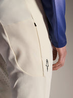 Alpinestars A-Aria Elite broek, ecru gebroken witte performance broek, close-up van zijzak met rits en laserperforaties voor ventilatie, minimalistisch logodetail, high-stretch stof voor mountainbiken