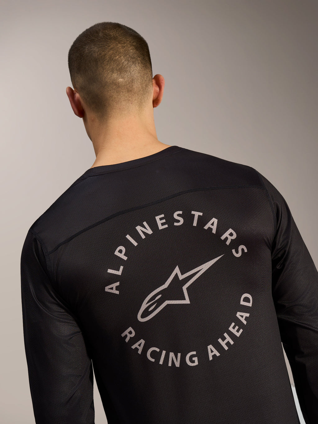Zwarte A-Dura Air jersey met lange mouwen, rugdetail met cirkelvormig Alpinestars Racing Ahead-logo op mesh-stof.