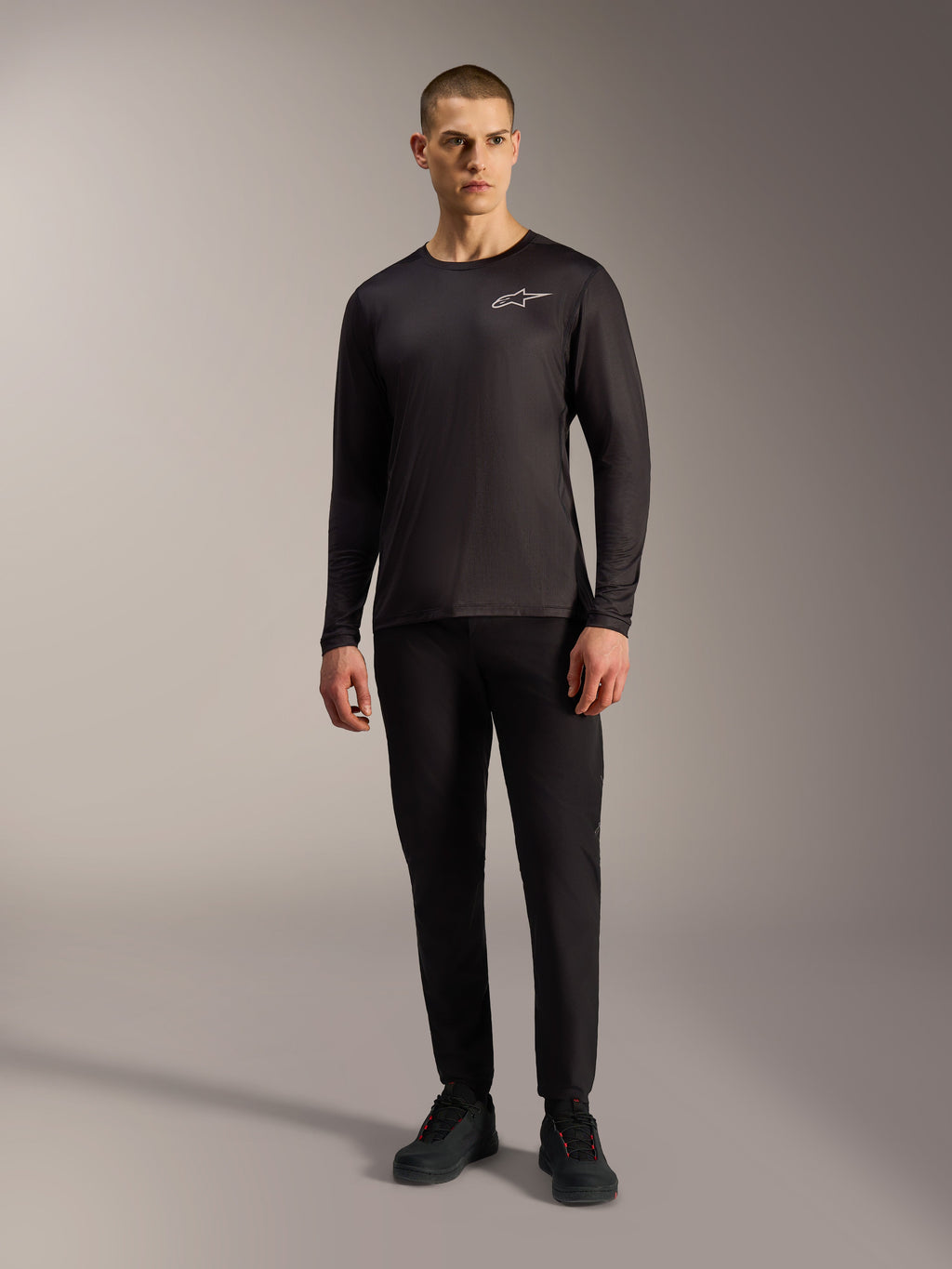Zwarte A-Dura Air jersey met lange mouwen en wit Alpinestars-logo, vochtafvoerende MTB-kleding op een mannelijk model.