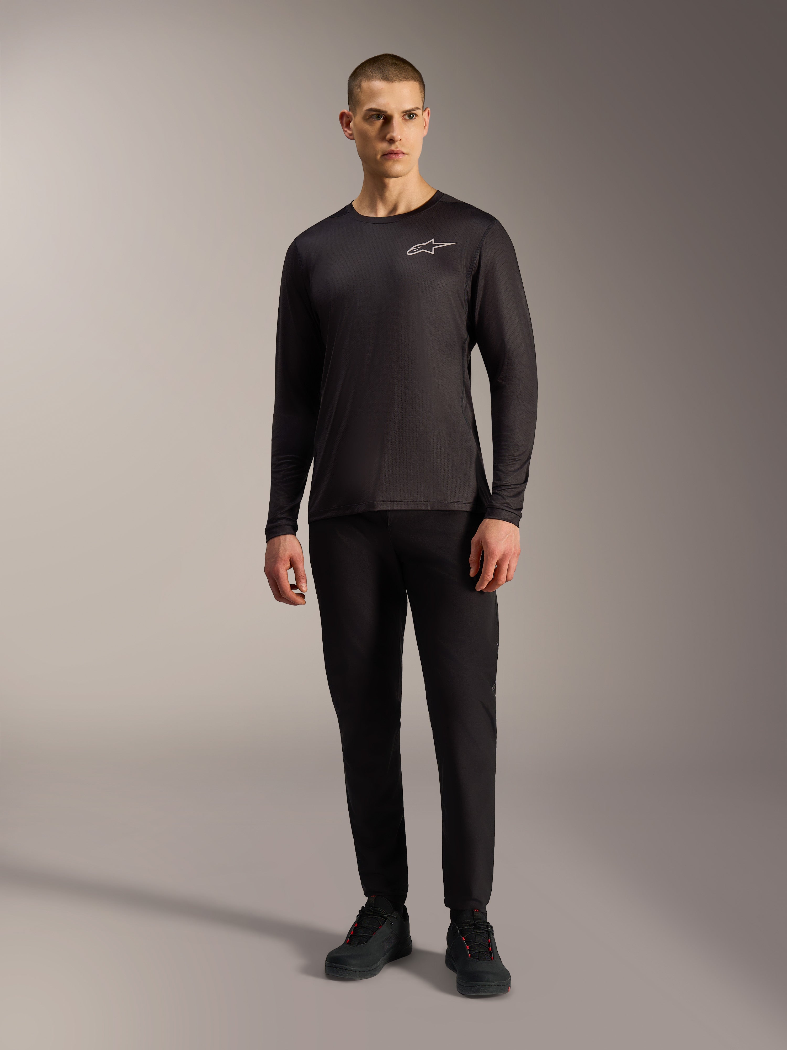 Zwarte A-Dura Air jersey met lange mouwen en wit Alpinestars-logo, vochtafvoerende MTB-kleding op een mannelijk model.