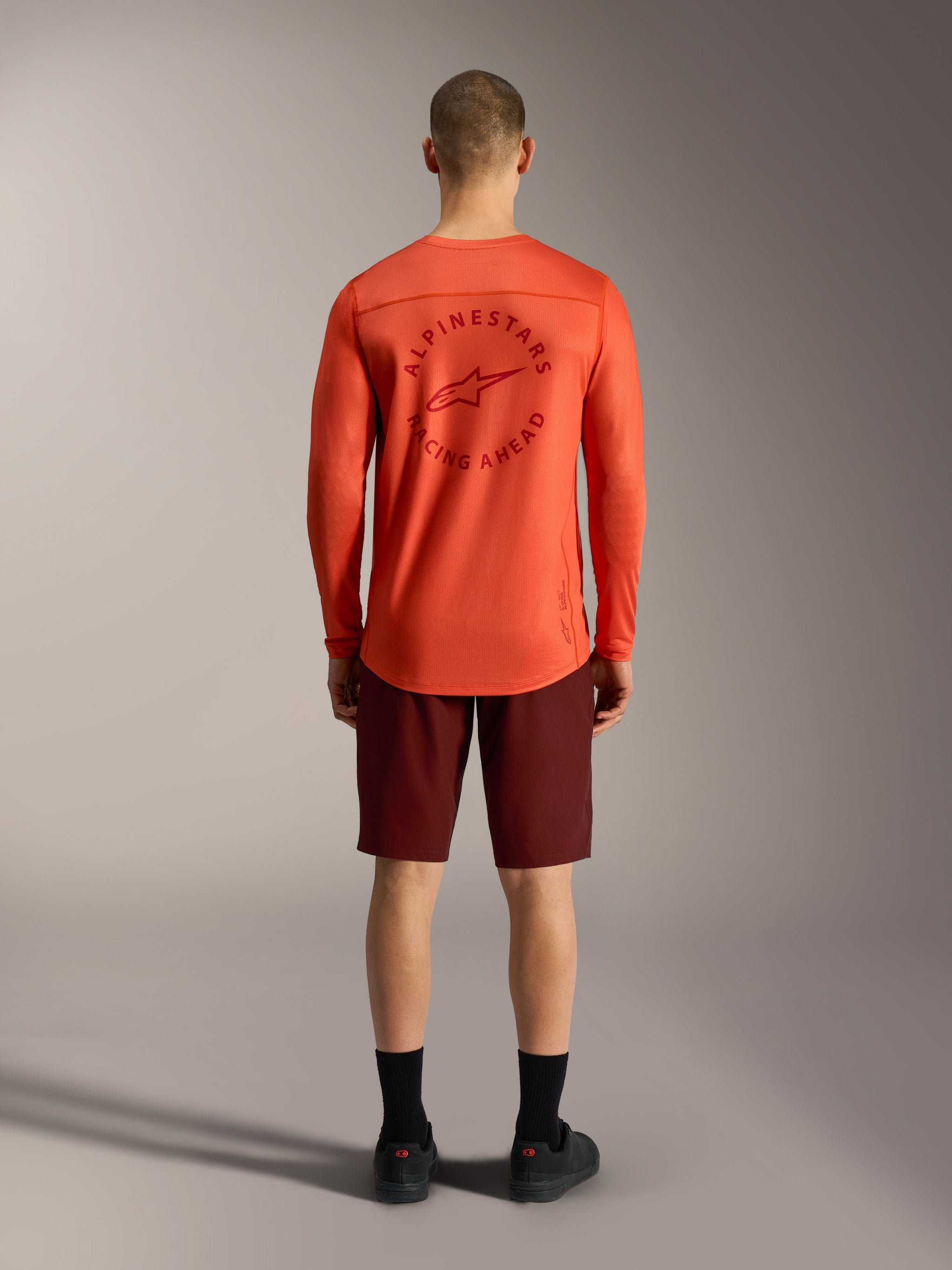 Oranje A-Dura Air LS Jersey en bordeauxrode Ride shorts, achteraanzicht van technische Alpinestars MTB-kleding.