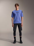 Alpinestars A-Aria Elite Shorts, MTB mountainbike shorts, Black Titanium, gedragen met blauwe jersey met korte mouwen, kniebeschermers en zwarte fietsschoenen, full-body studio-opname, hoogwaardige mountainbikekleding