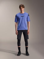Alpinestars A-Aria Elite Shorts, MTB mountainbike shorts, Black Titanium, gedragen met blauwe jersey met korte mouwen, kniebeschermers en zwarte fietsschoenen, full-body studio-opname, hoogwaardige mountainbikekleding