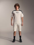 Alpinestars A-Aria Elite Shorts, mountainbike shorts, ecru, gedragen met bijpassend shirt met korte mouwen met zwarte schouderpanelen en logo, casual sportieve look met perforaties aan de voorzijde, performance MTB-kleding