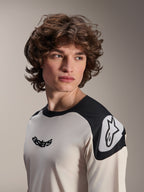 Alpinestars A-Aria Polartec Elite Jersey met korte mouwen, ecru met zwarte schouderpanelen, zwart Astars-logo op de borst en wit Astars-logo op de schouder, hoogwaardige mountainbikekleding gedragen door een model