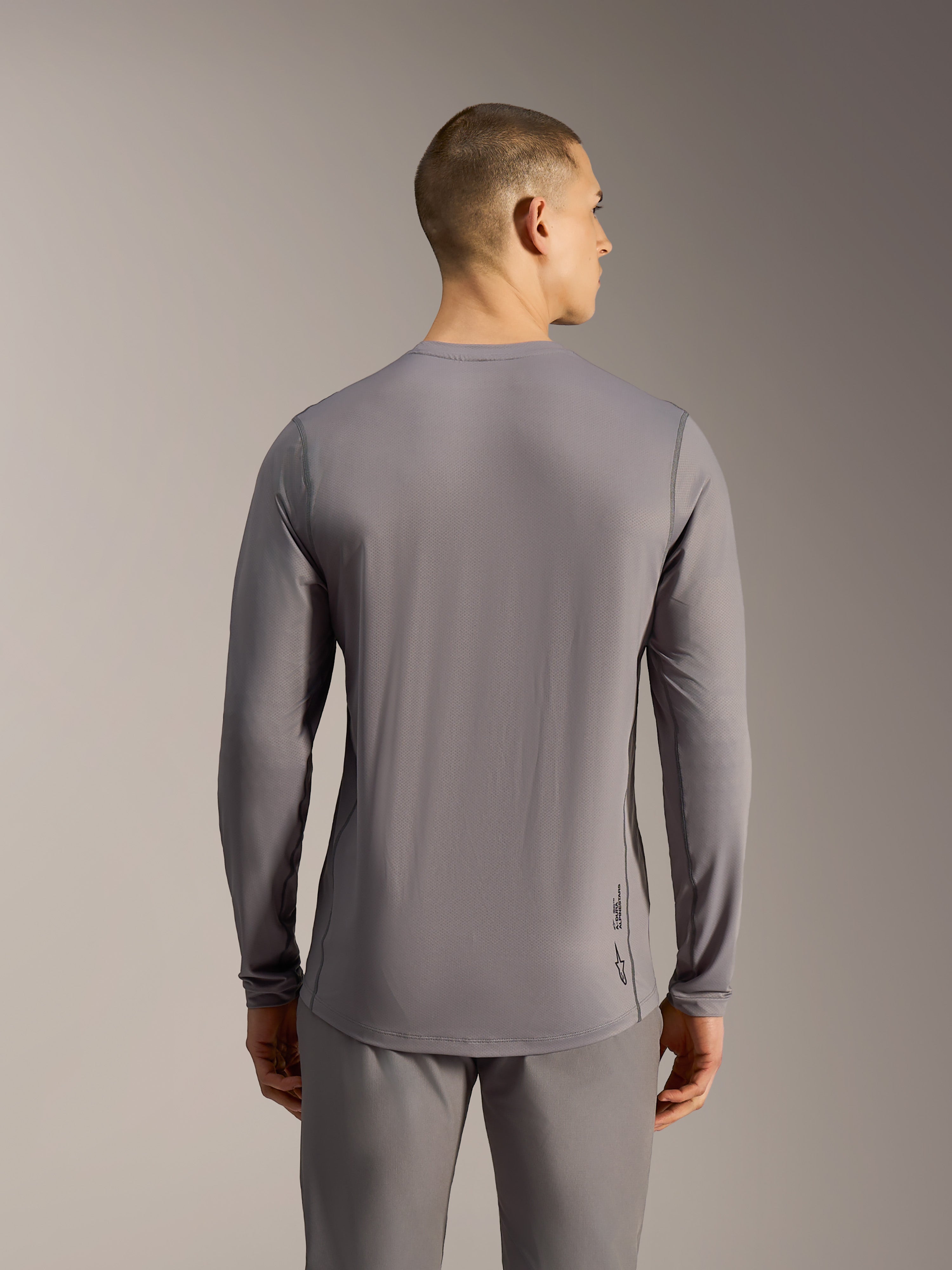 Grijze A-Dura Ride MTB-trui met lange mouwen, jacquard stretchstof en een verlengde achterkant gezien vanaf de rug.