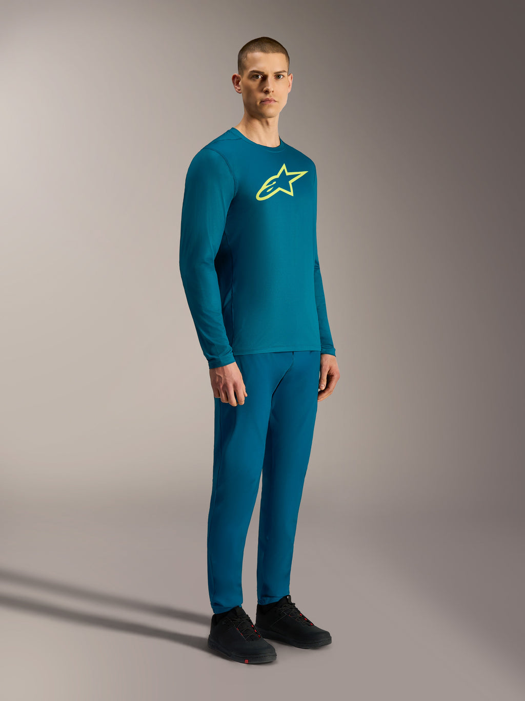 A-Dura Ride trui met lange mouwen in blauwgroen met geel Astars-logo en bijpassende technische MTB-kleding.