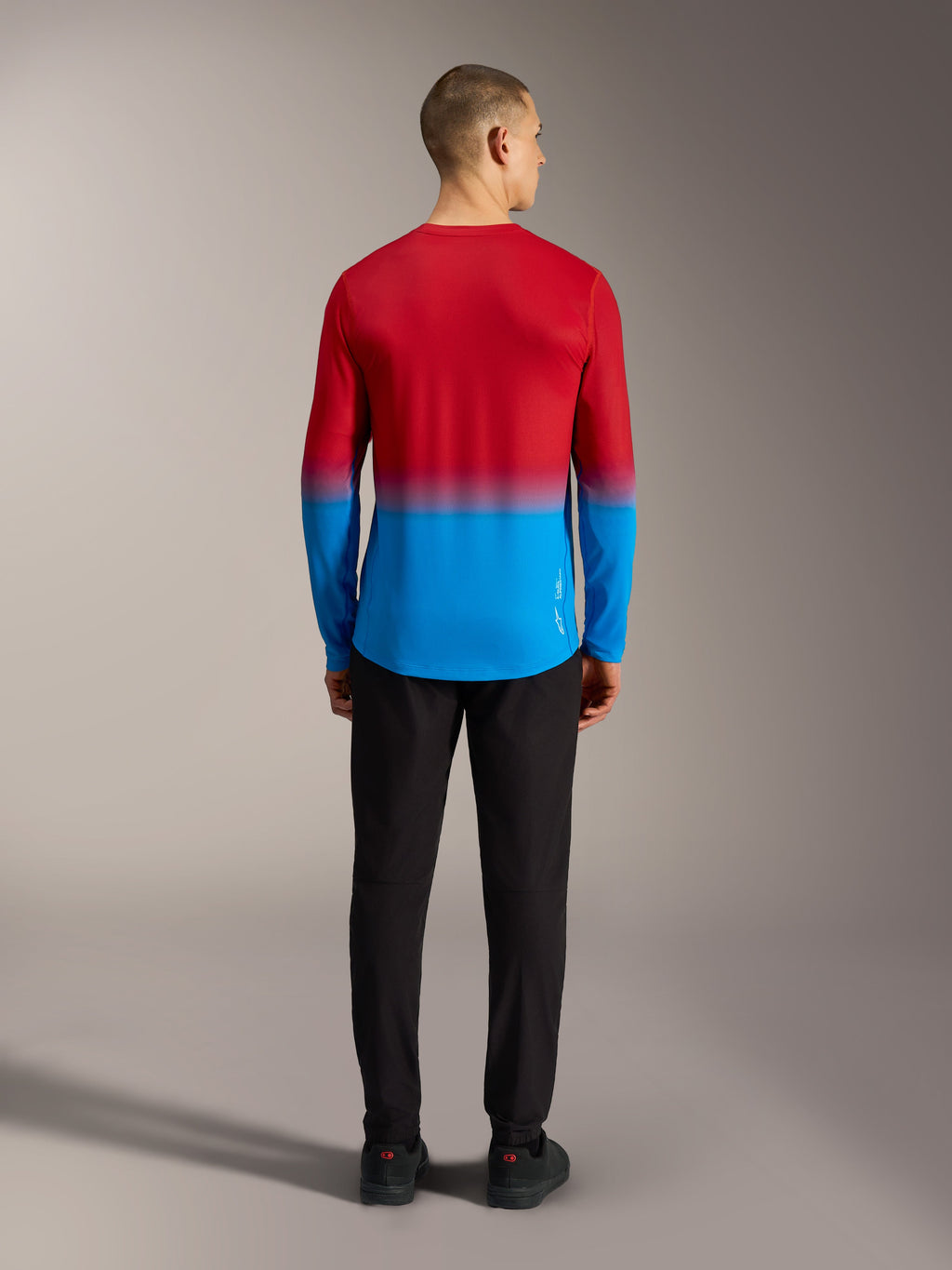 Alpinestars A-Dura ASTARS 2.0 MTB-jersey met lange mouwen, rood en blauw kleurverloop, rugaanzicht op model.