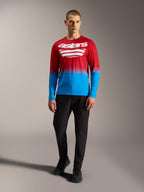 A-Dura ASTARS 2.0 MTB-jersey met lange mouwen, rood-blauw kleurverloop en witte logo's, met een zwarte broek.