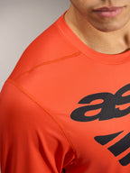 Oranje A-Dura ASTARS 2.0 jersey met lange mouwen, zwarte logo's en ademende, getextureerde prestatiestof.