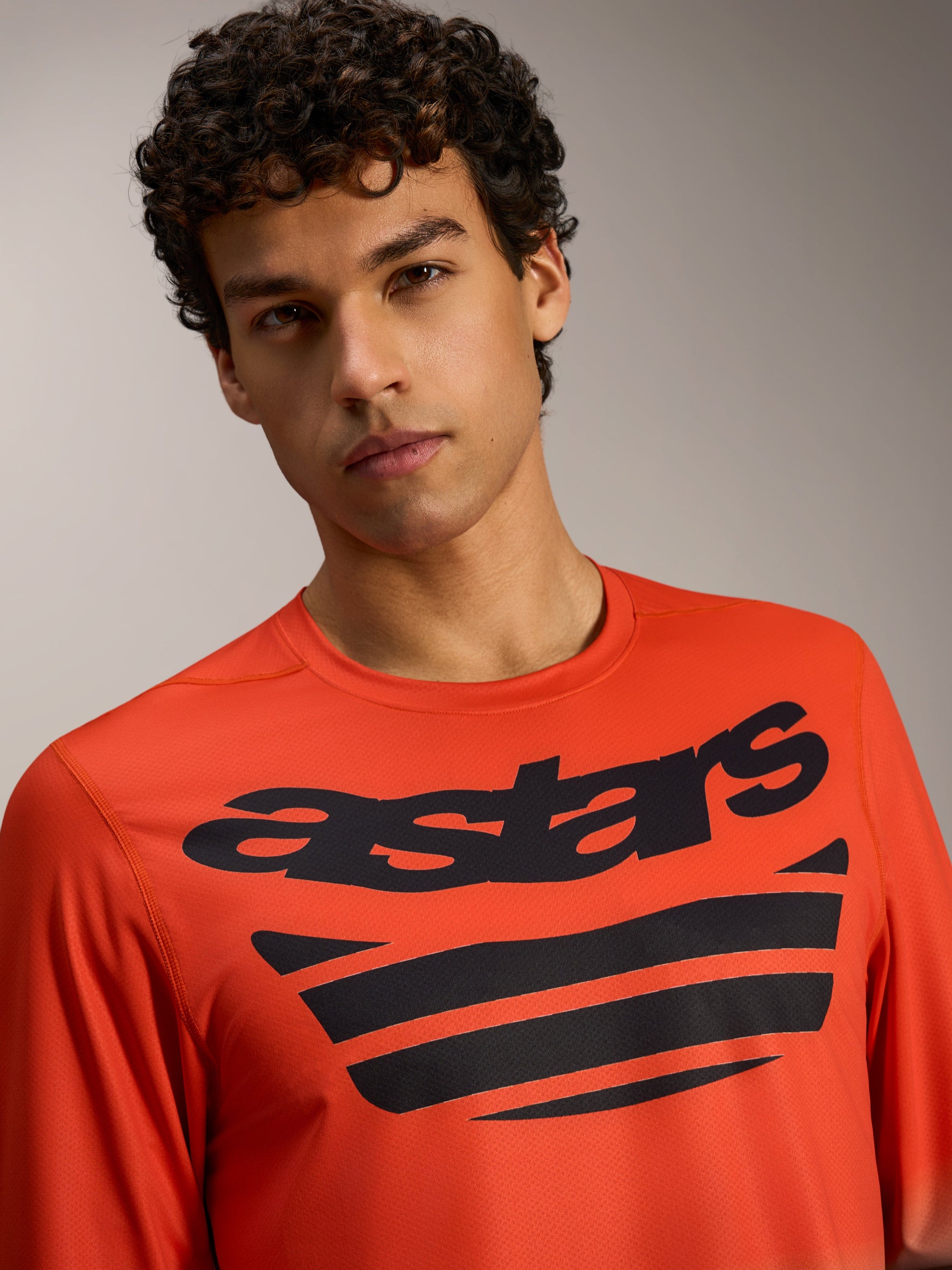 Oranje A-Dura ASTARS Jersey 2.0 met lange mouwen, opvallende zwarte borstlogo's, technische kleding voor MTB-trailrijders.