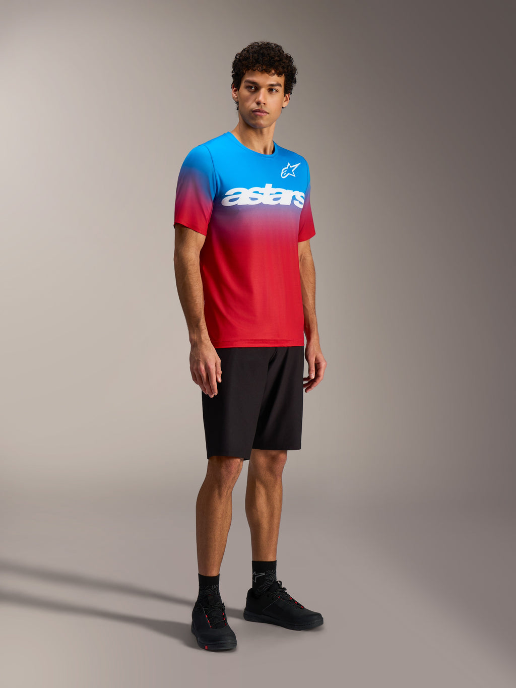 Alpinestars A-Dura ASTARS Jersey 2.0, MTB-top met felrood en blauw kleurverloop en wit woordmerk op de borst.