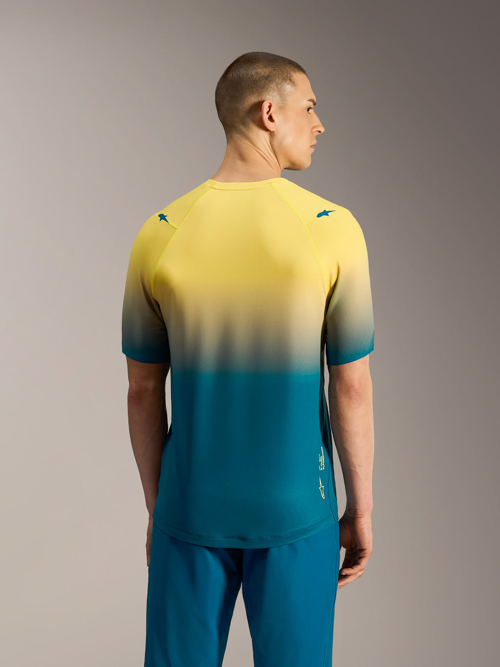 A-Dura ASTARS 2.0 MTB-jersey met korte mouwen, geel naar blauwgroen kleurverloop, achteraanzicht van technisch shirt.