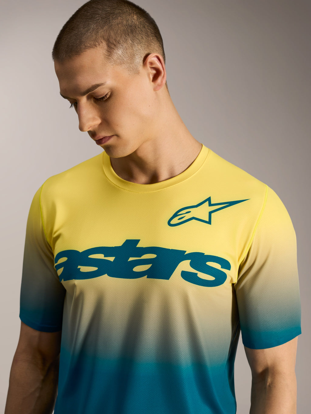 A-Dura ASTARS Jersey 2.0, MTB-shirt met geel-blauw kleurverloop, korte mouwen, opvallend woordmerk en sterlogo op de borst.