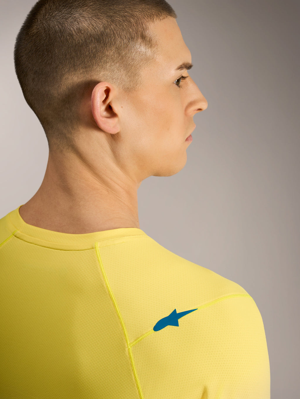 Geel fluo A-Dura ASTARS Jersey 2.0, achteraanzicht met blauw schouderlogo en ademende jacquard MTB-stof.