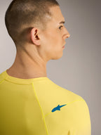 Geel fluo A-Dura ASTARS Jersey 2.0, achteraanzicht met blauw schouderlogo en ademende jacquard MTB-stof.