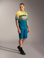 A-Dura ASTARS 2.0 MTB-jersey met geel-blauw kleurverloop en borstlogo, korte mouwen, gedragen door een model.