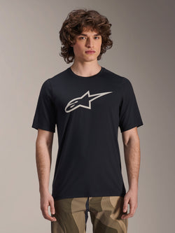 Alpinestars A-Dura Astar Jersey met korte mouwen, zwart MTB-shirt met wit sterlogo, gedragen met camouflagebroek, casual mountainbike-kleding, technische vochtafvoerende stof