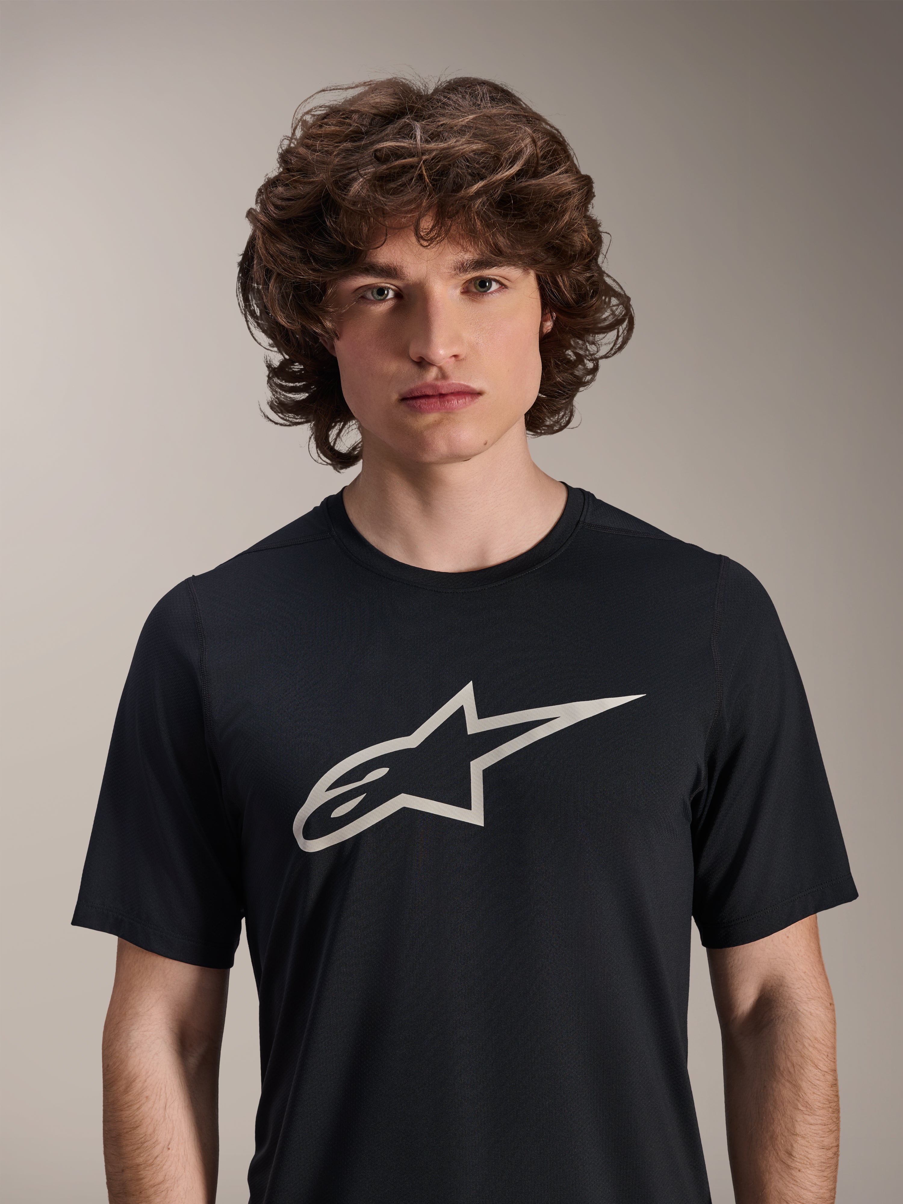 Alpinestars A-Dura Astar jersey met korte mouwen, zwart, voorzien van een groot wit Astar-logo op de borst, gedragen door een mannelijk model, casual mountainbike-performancekleding