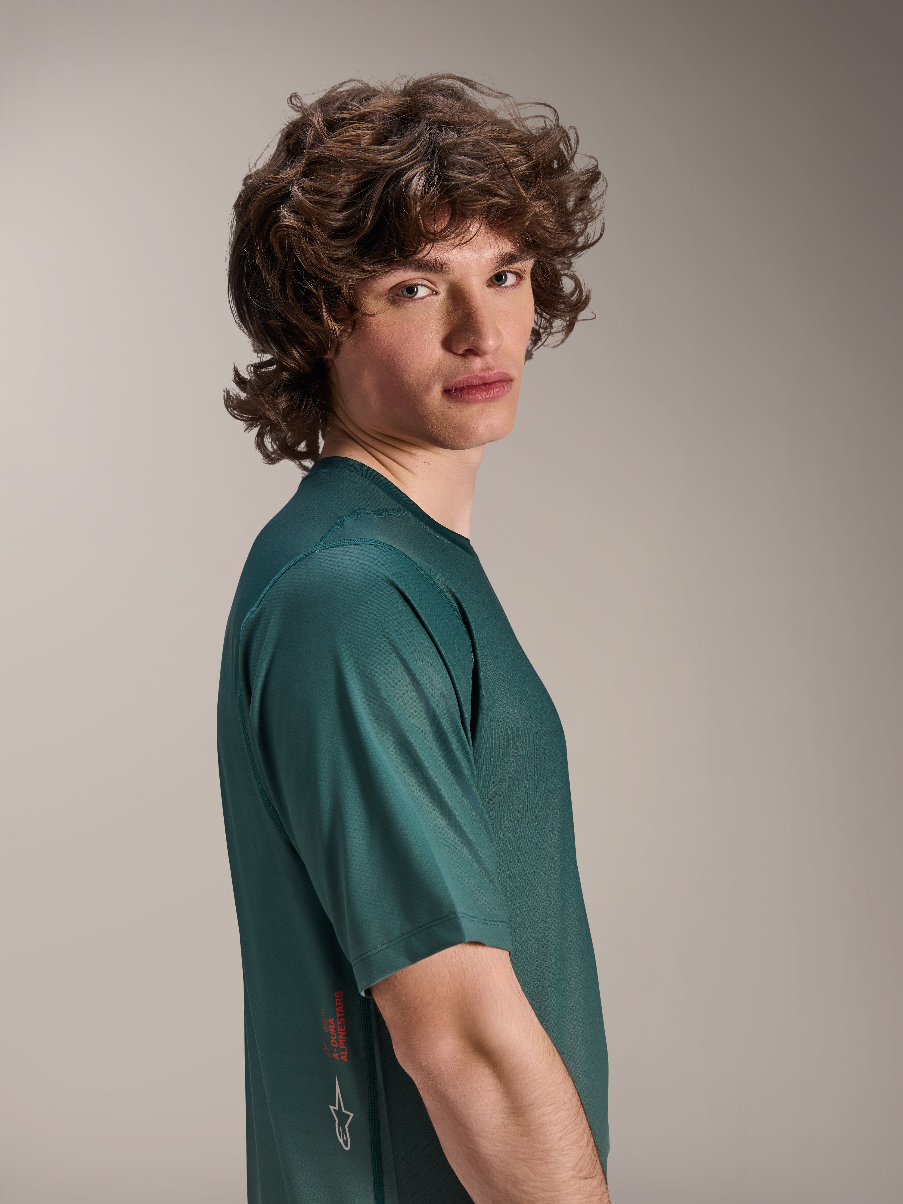 Alpinestars A-Dura Rise Jersey, MTB-jersey met korte mouwen, Silver Pine groen, mannelijk model draagt vochtafvoerende jacquard stof, rood A-Dura Alpinestars woordmerk en wit logo aan de zijkant, performance trail-uitrusting