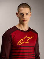A-Dura Elite jersey met lange mouwen in bordeauxrood, met geel sterlogo en streeppatroon voor MTB-prestaties.