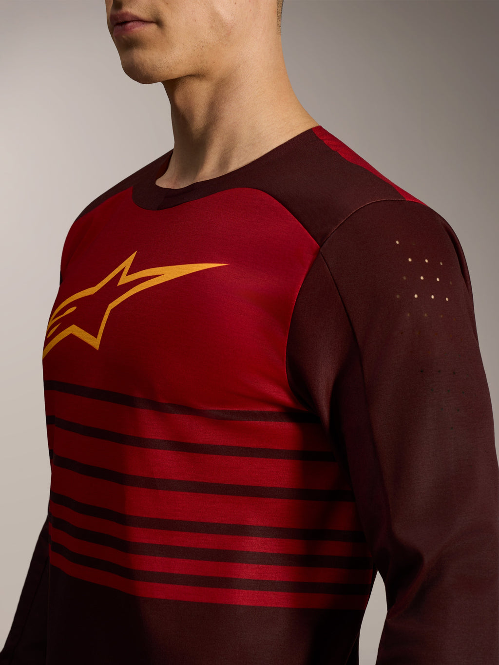 Alpinestars A-Dura Elite 2.0 jersey, bordeauxrood, lange mouwen, geel borstlogo en lasergesneden biceps-perforaties.