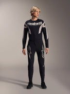 Alpinestars A-Supra Melt broek en bijpassende jersey met lange mouwen, model draagt zwarte MTB-kit met grote witte sterafbeeldingen op de dijen en 'astars' branding op de borst, professionele mountainbike racekleding