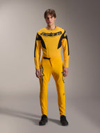 Limited Edition A-Supra Melt Gold-uitrustingsset, Alpinestars mountainbikekleding, donkergeel en zwart, model draagt jersey met lange mouwen met opvallend 'astars'-logo op de borst en bijpassende performance-broek, voorzien van lasergesneden ventilatie op de binnendijen en een veilige ratelsluiting, professionele MTB-racekit
