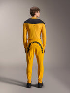 Alpinestars Limited Edition A-Supra Melt Gold Jersey, MTB-shirt met lange mouwen, donkergeel, achteraanzicht, met zwarte schouderpanelen, gedragen met bijpassende gele broek met grote zwarte merknaam op de achterzijde, performance fietskleding