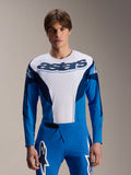 Alpinestars A-Supra Melt Jersey met lange mouwen, blauw en wit MTB-shirt met opvallende astars-branding op de borst en donkerblauwe mouwen, gedragen met bijpassende blauwe racebroek met witte sterlogo's, hoogwaardige mountainbike-kleding