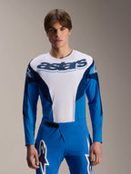 Alpinestars A-Supra Melt Jersey met lange mouwen, blauw en wit MTB-shirt met opvallende astars-branding op de borst en donkerblauwe mouwen, gedragen met bijpassende blauwe racebroek met witte sterlogo's, hoogwaardige mountainbike-kleding
