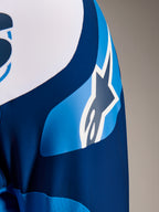 Alpinestars A-Supra Melt Jersey, MTB-shirt met lange mouwen in blauw, close-up van de mouw met de ASTARS-logografiek en micro-geperforeerde stof voor ventilatie