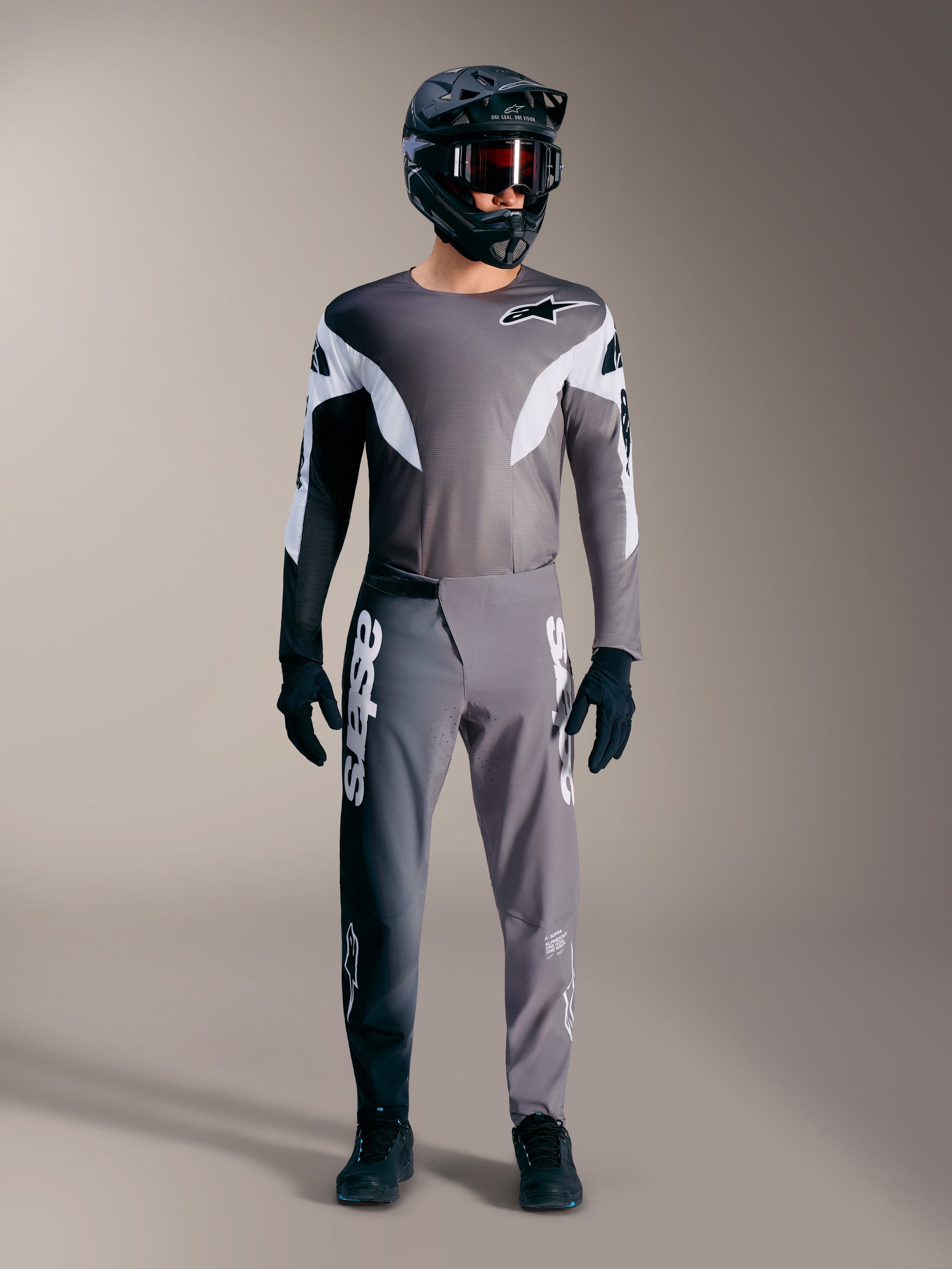 Alpinestars A-Supra Elite MTB gear in faded gray, featuring performance jersey and pants with bold white logos.