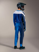 A-Supra Elite MTB-uitrusting in Faded Bright Blue, shirt en broek van achteren gezien met een full-face helm.