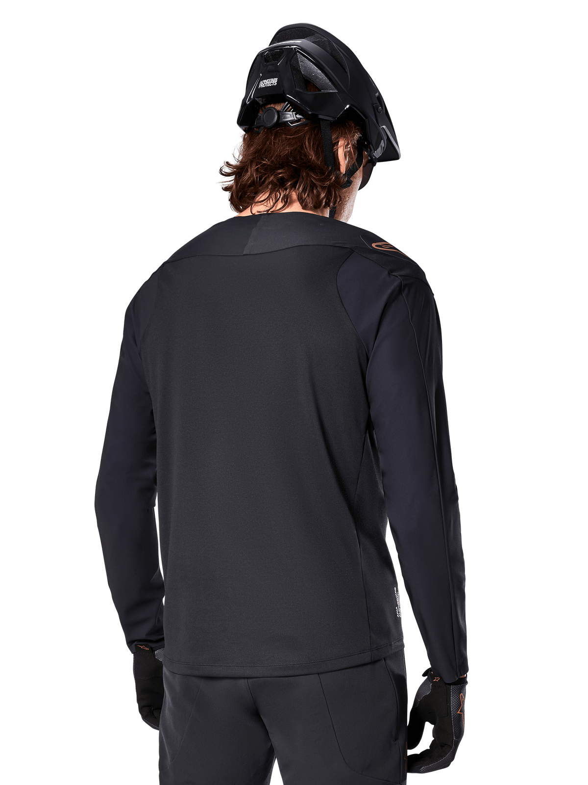 Alpinestars A-Aria Polartec Switch Jersey met lange mouwen, zwart, achteraanzicht, gedragen met een zwarte MTB-helm en handschoenen, voorzien van een drop tail-ontwerp voor off-road prestaties