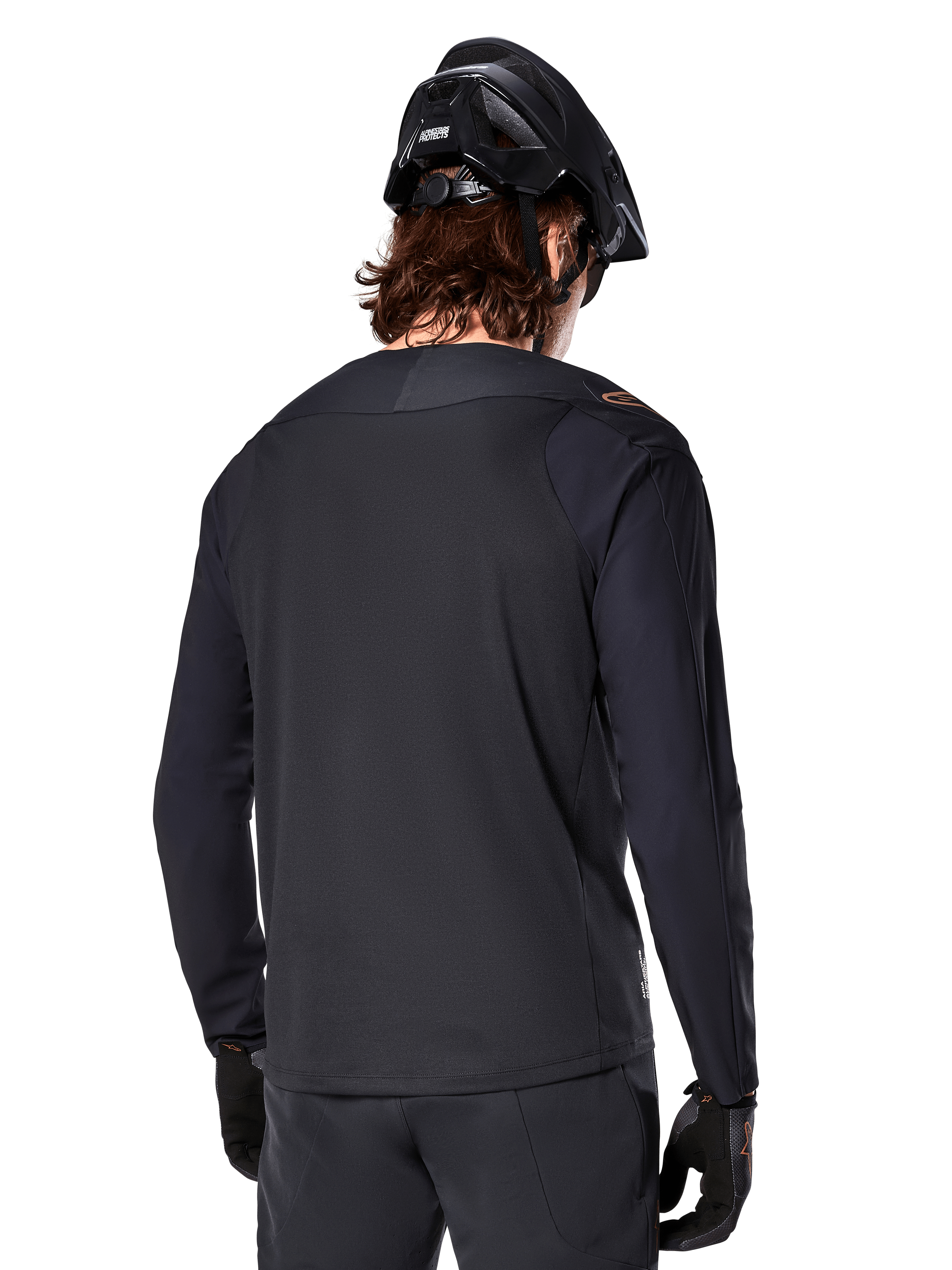 Alpinestars A-Aria Polartec Switch Jersey met lange mouwen, zwart, achteraanzicht, gedragen met een zwarte MTB-helm en handschoenen, voorzien van een drop tail-ontwerp voor off-road prestaties